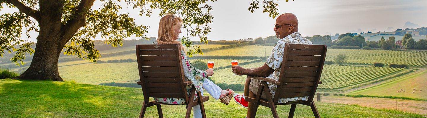 Two people sitting enjoying a glass of wine overlooking Charles Palmer Vineyards